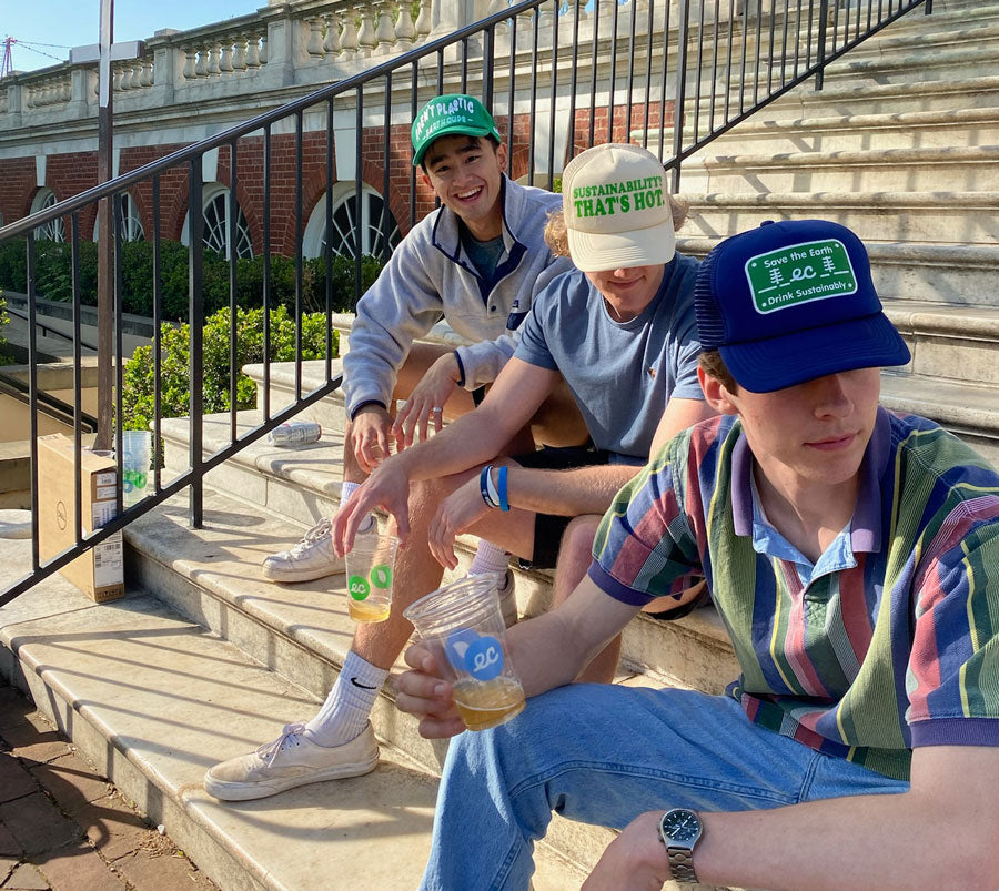 College Students sitting on steps wearing Earth Brands Hats