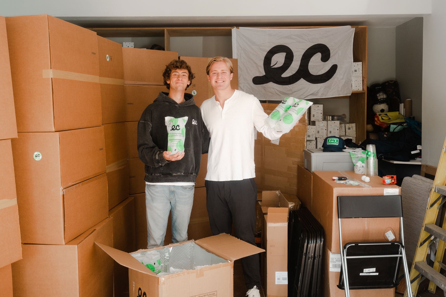 Earth Cups Founders In Garage Full Of Boxes of Earth Cups